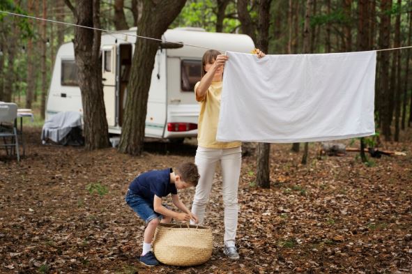 Mother and son drying off wet laundry after the rain